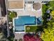 Aerial view of a sparkling pool and spa with comfortable patio seating surrounded by lush greenery and colorful flowers at 3641 E Los Gatos Dr, Phoenix, AZ 85050