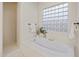 Bright bathroom features a soaking tub with glass block window and separate walk-in shower at 3641 E Los Gatos Dr, Phoenix, AZ 85050