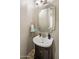 Stylish powder bathroom features a pedestal sink, decorative mirror, and modern fixtures at 3641 E Los Gatos Dr, Phoenix, AZ 85050