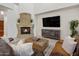 Inviting living room with a stone fireplace, comfortable seating, and a modern TV at 3641 E Los Gatos Dr, Phoenix, AZ 85050