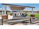 Covered barbecue area includes picnic tables and BBQ pits for fun outdoor gatherings at 36525 W Maddaloni Ave, Maricopa, AZ 85138
