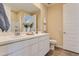 A well-lit bathroom showcases double sinks with white countertops and wood-like flooring at 36525 W Maddaloni Ave, Maricopa, AZ 85138