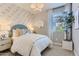 This cozy bedroom with large windows brings light to the blue-themed decorations, including a cloud wallpaper at 36525 W Maddaloni Ave, Maricopa, AZ 85138