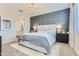 Inviting main bedroom with a statement wall, plush bedding, and elegant chandelier at 36525 W Maddaloni Ave, Maricopa, AZ 85138
