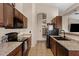 Galley kitchen boasts granite countertops, brown cabinetry, and a black appliance package at 3711 E Long Lake Rd, Phoenix, AZ 85048