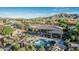 An aerial view of a backyard with outdoor kitchen, pool and spa, lush landscaping, and mountain views at 3754 E Flintlock Dr, Queen Creek, AZ 85142