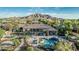 Aerial view of a backyard with outdoor kitchen, in-ground pool and spa, lush landscaping, and mountain views at 3754 E Flintlock Dr, Queen Creek, AZ 85142