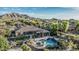 An aerial view features a beautiful backyard with outdoor kitchen, in-ground pool and spa, and mountain views at 3754 E Flintlock Dr, Queen Creek, AZ 85142