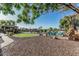 Landscaped backyard with manicured lawn, cozy fire pit area, and lush greenery, perfect for relaxing at 3754 E Flintlock Dr, Queen Creek, AZ 85142