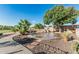 Unique water feature in a landscaped backyard, with walking paths and a variety of plants and trees at 3754 E Flintlock Dr, Queen Creek, AZ 85142