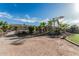 Landscaped backyard features desert landscape with palm trees, grass area, and decorative rocks, all enclosed with wrought iron fencing at 3754 E Flintlock Dr, Queen Creek, AZ 85142