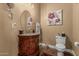 Elegant powder room featuring a dark wood vanity, granite countertop, and decorative floral accents at 3754 E Flintlock Dr, Queen Creek, AZ 85142