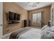 Bedroom featuring a ceiling fan, window, and mounted TV at 3754 E Flintlock Dr, Queen Creek, AZ 85142