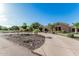 Beautiful house with circular driveway, desert landscaping, manicured lawn and lots of palm trees at 3754 E Flintlock Dr, Queen Creek, AZ 85142