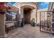 View of the home's gated courtyard entrance with stone archway, potted plants, and a seating area at 3754 E Flintlock Dr, Queen Creek, AZ 85142
