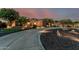 Stunning desert home with a long, winding driveway and lush landscaping at twilight at 3754 E Flintlock Dr, Queen Creek, AZ 85142