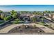 Beautiful aerial view of home showcasing circular driveway, rock features, desert landscaping, well-manicured lawn and charming architecture at 3754 E Flintlock Dr, Queen Creek, AZ 85142