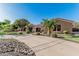 Lush landscaping frames the front of this desert home with a circular driveway and gated stone archway entrance at 3754 E Flintlock Dr, Queen Creek, AZ 85142
