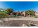 Beautiful front exterior showcasing circular driveway, a desert rock front yard and several palm trees at 3754 E Flintlock Dr, Queen Creek, AZ 85142