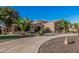 A large desert home with meticulous landscaping, a circular driveway and mature palm trees at 3754 E Flintlock Dr, Queen Creek, AZ 85142