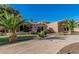 An elegant home with a circular driveway, manicured landscaping, and towering palm trees at 3754 E Flintlock Dr, Queen Creek, AZ 85142