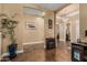 Hallway featuring multiple archways, warm lighting, a decorative table with a fireplace, and access to bedrooms at 3754 E Flintlock Dr, Queen Creek, AZ 85142