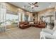 Spacious living room features large windows, tan walls, and a comfortable leather sectional sofa at 3754 E Flintlock Dr, Queen Creek, AZ 85142