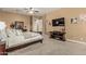 This cozy bedroom with carpet features a dark brown entertainment center and dresser at 3754 E Flintlock Dr, Queen Creek, AZ 85142