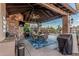 Covered outdoor kitchen with seating, grill, and a view of the pool and landscaped backyard at 3754 E Flintlock Dr, Queen Creek, AZ 85142