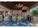 Covered outdoor kitchen and dining space with a built-in BBQ, dining table, and fan for comfortable entertaining at 3754 E Flintlock Dr, Queen Creek, AZ 85142