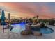 Swimming pool, diving board, water fall feature, and jacuzzi with gorgeous sunset, creating a relaxing backyard at 3754 E Flintlock Dr, Queen Creek, AZ 85142