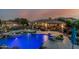 A swimming pool with rocks, diving board, and hot tub, alongside a covered outdoor dining area with sunset sky at 3754 E Flintlock Dr, Queen Creek, AZ 85142