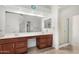 Bright bathroom featuring dual sinks, a large mirror, plenty of storage and a glass shower at 411 N Cordoba Pl, Chandler, AZ 85226