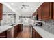 Well-appointed kitchen with wood cabinets, tile backsplash, stainless steel appliances, and marble counters at 411 N Cordoba Pl, Chandler, AZ 85226