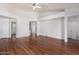 Large living room showcasing wood floors, neutral paint, ceiling fan, and multiple entrances at 411 N Cordoba Pl, Chandler, AZ 85226