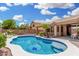 Sparkling in-ground pool with a sun shelf, surrounded by lush landscaping and a well-maintained patio at 411 N Cordoba Pl, Chandler, AZ 85226