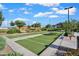 Community bocce ball court featuring manicured grass, concrete borders, benches, and lush landscaping at 4156 E Jesse St, Gilbert, AZ 85295