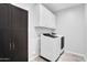 Laundry room with white cabinets, dark wood storage and modern washer and dryer at 4156 E Jesse St, Gilbert, AZ 85295