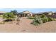 Relaxing backyard with covered patio, artificial turf, and vibrant desert landscaping offering comfort and style at 41769 W Canasta Ln, Maricopa, AZ 85138