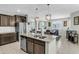 Open kitchen with island, stainless steel appliances, and views of the dining and living areas at 41769 W Canasta Ln, Maricopa, AZ 85138