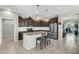 Stylish kitchen with stainless steel appliances, dark wood cabinets, island and decorative pendant lights at 41769 W Canasta Ln, Maricopa, AZ 85138