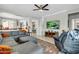 Inviting living room featuring a large sectional sofa, TV, and open access to the kitchen and dining area at 41769 W Canasta Ln, Maricopa, AZ 85138