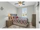 Cozy bedroom with wood-look flooring, ceiling fan, and shuttered window at 41769 W Canasta Ln, Maricopa, AZ 85138