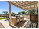Covered patio with outdoor kitchen featuring a built-in grill, creating a perfect space for outdoor cooking at 41769 W Canasta Ln, Maricopa, AZ 85138