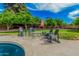 Lush backyard seating area includes comfortable chairs, a table, an umbrella, and view of the pool at 4317 E Yucca St, Phoenix, AZ 85028