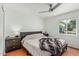 Bright bedroom features a ceiling fan, hardwood floors, and a window offering natural light at 4317 E Yucca St, Phoenix, AZ 85028