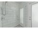 Bright shower with white subway tile, pebble stone flooring, and a glass door at 4317 E Yucca St, Phoenix, AZ 85028