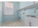Laundry room with tiled floor, sink and cabinet, a large window and light blue walls at 4413 E Odessa Dr, San Tan Valley, AZ 85140