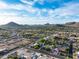 An aerial shot reveals a community nestled against mountain views, with beautiful homes and vibrant green spaces at 4637 W Misty Willow Ln, Glendale, AZ 85310