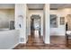 Bright hallway with hardwood floors, modern columns, and views of the living room fireplace at 4637 W Misty Willow Ln, Glendale, AZ 85310